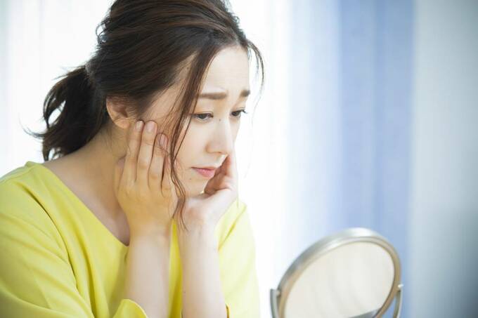 女性が顔をおさえている様子