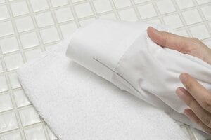 シミがついた生地の下にタオルを敷く