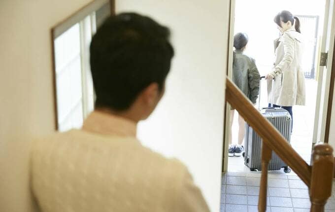 玄関の女性を見る男性後ろ姿