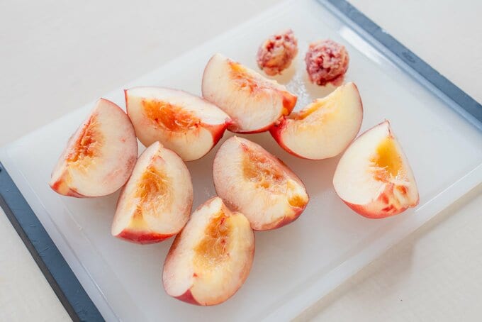 4等分のくし形切りにした桃がまな板にのっている様子