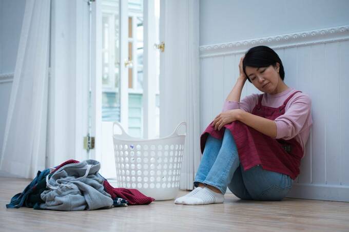 座り込んで頭を抱える女性