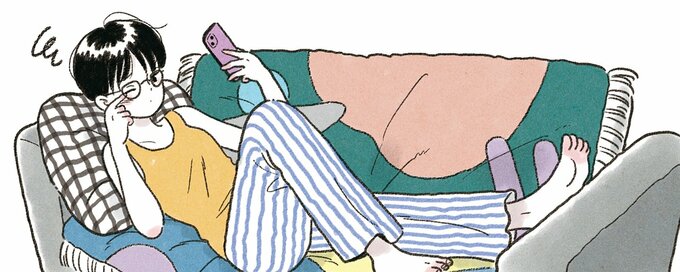 ソファに寝転んでスマホを観る女性