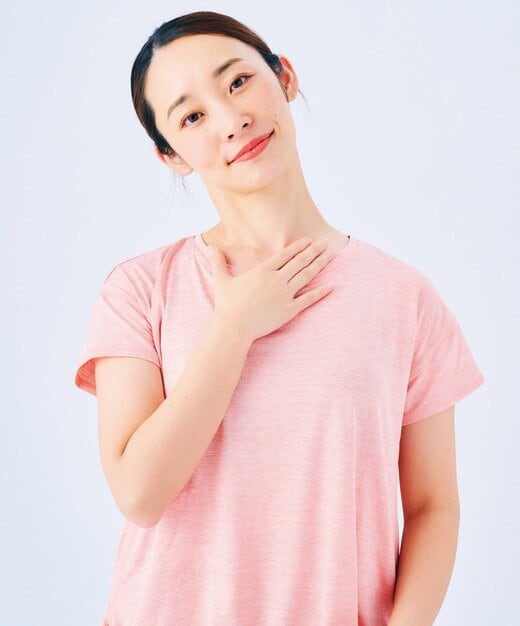 首を傾けて手を鎖骨に置く女性