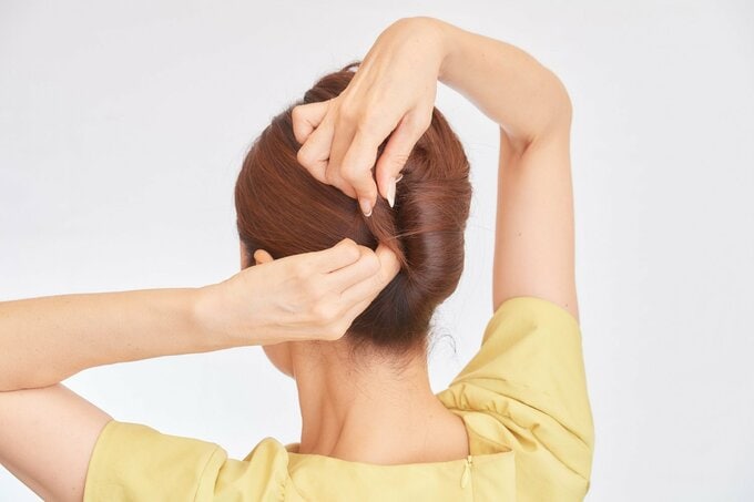 髪にピンをさす女性