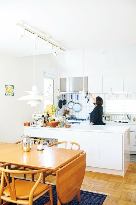 白が基調のキッチンに立つ女性