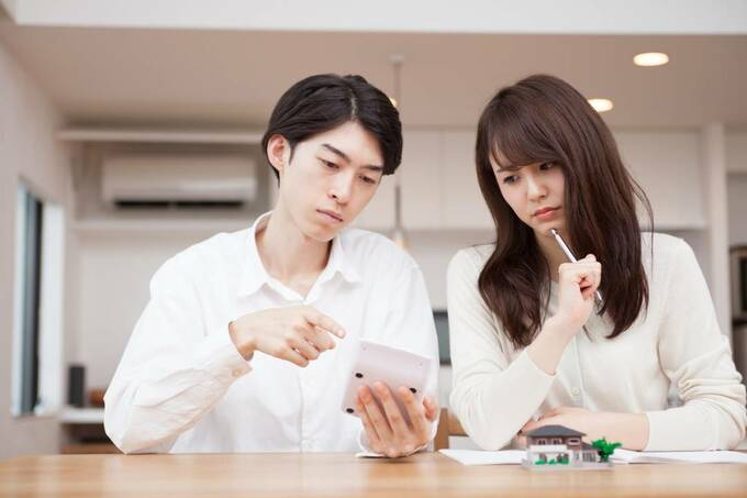 電卓を見て悩む男女