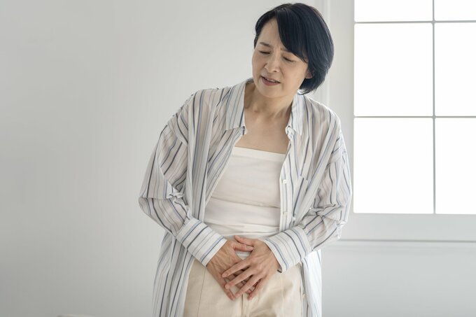 お腹を押さえる女性