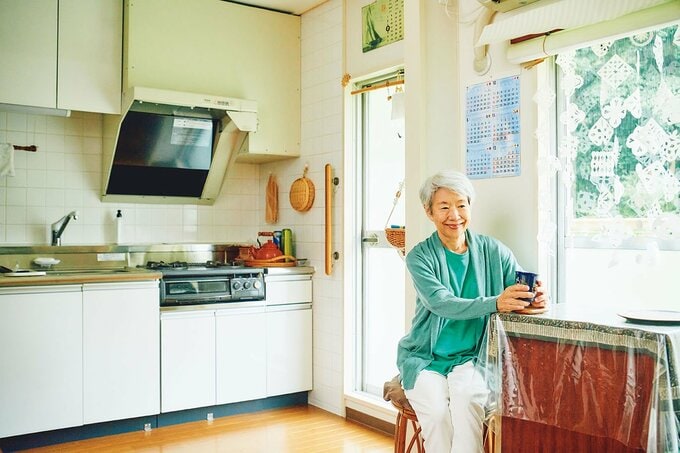 キッチン前の椅子に座る女性