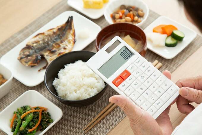 料理の前で電卓を持つ様子