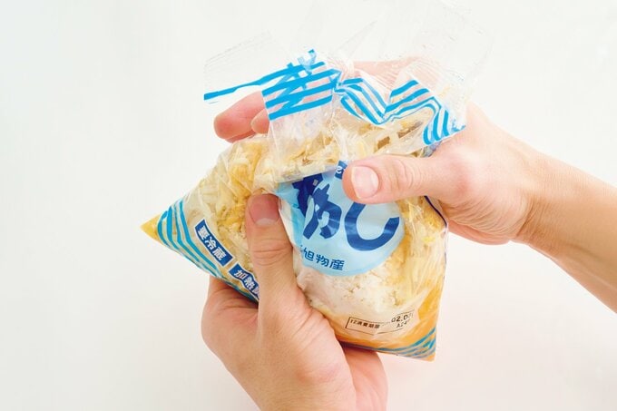 材料が入ったモヤシの袋をもむ手
