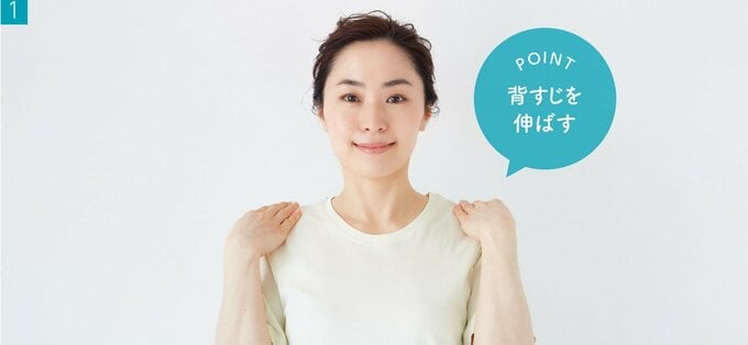 背すじを伸ばして両手の肩の上にのせる女性