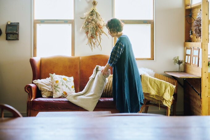ソファ周りを綺麗にする女性