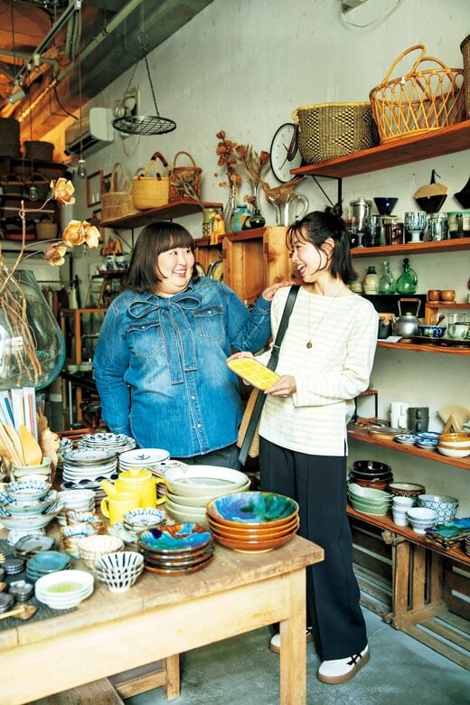 食器の並ぶお店で顔を見合わせて笑う2人の女性