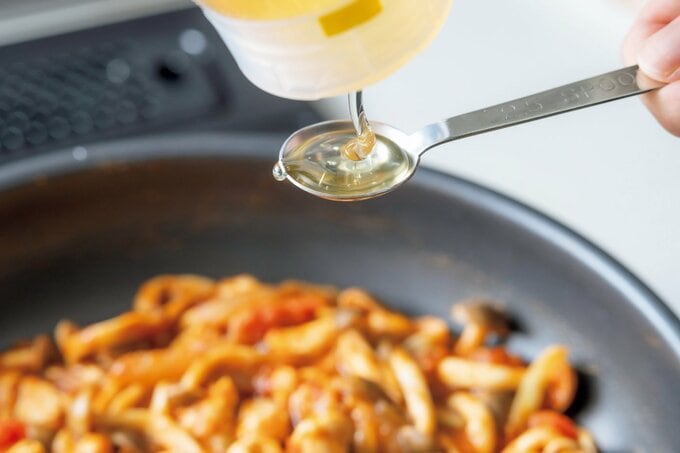 はちみつを計量スプーンに入れる様子