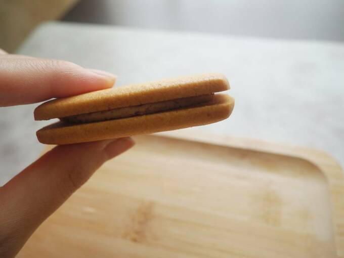 栗のクリームサンドクッキーを手に持つ