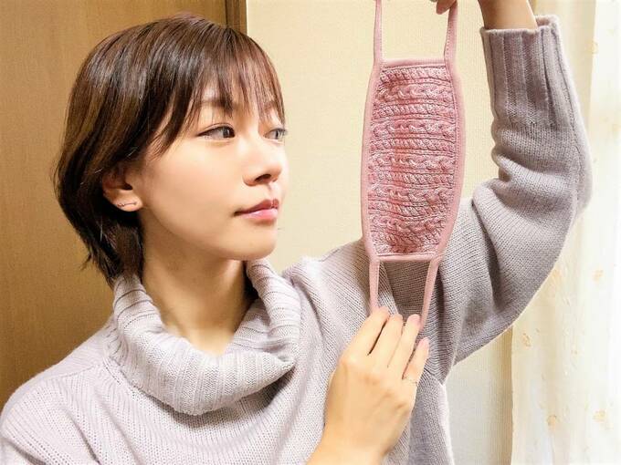 ピンクのニットマスクをのばす女性