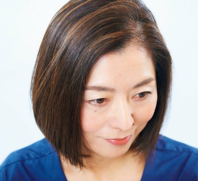 ネイビーのトップスを着た女性が下を向く様子