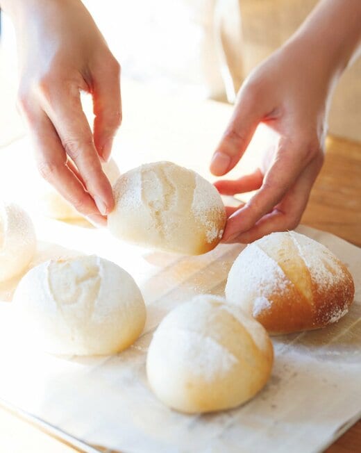 米粉でつくった丸パンを手に取る様子