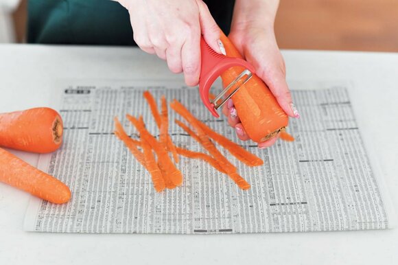 ニンジンの皮をピーラーでむく様子