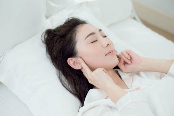 両手で耳の付け根をさわる