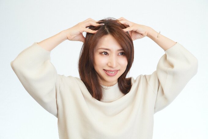 頭頂部をマッサージする女性