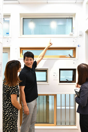 高所窓を指差す男性と女性2人