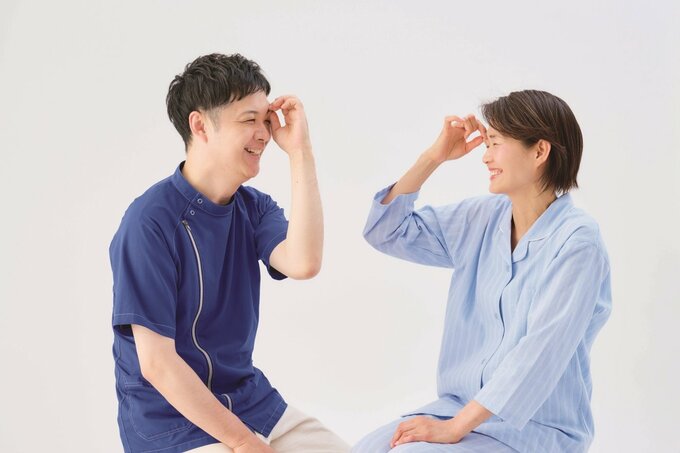 目のコリをほぐす男性と女性