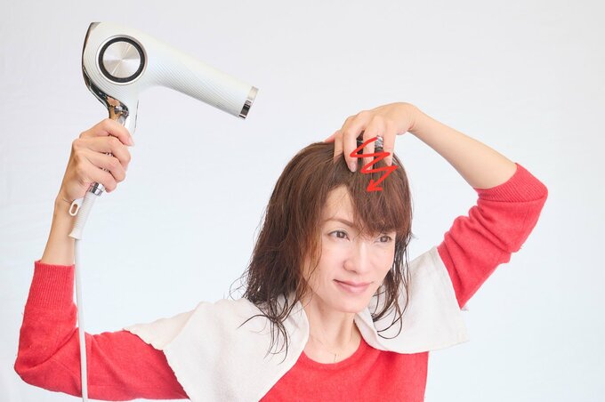 前髪を乾かす女性