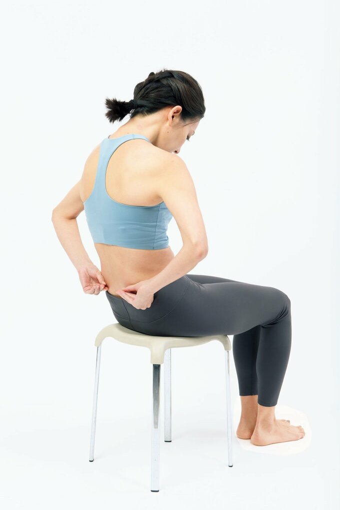 背中を丸めて腰肉をつまむ