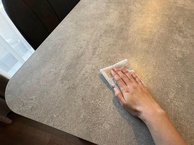 セラミック天板のダイニングテーブルをふいている手元