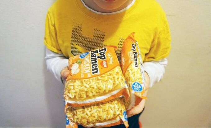インスタント麺を持つ子ども