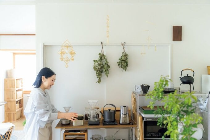 女性がキッチンでコーヒーセットを並べる様子