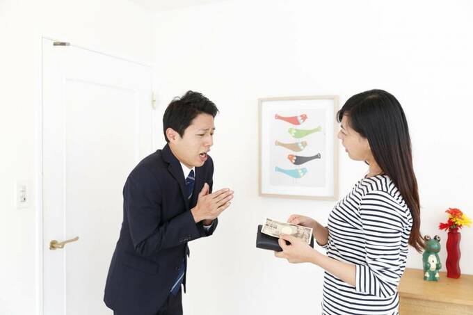 玄関に財布を持つ女性と男性