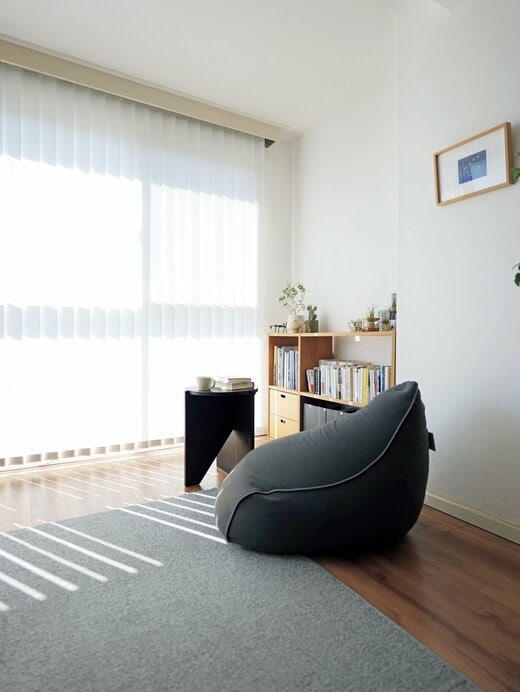 ビーズクッションと小さなテーブル、本棚が置かれた部屋