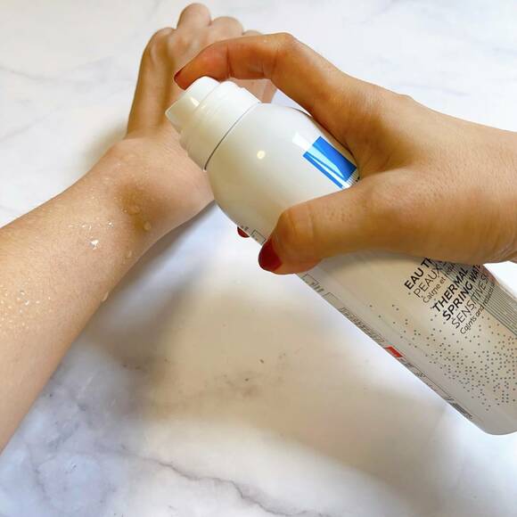 保湿スプレーを手にかける様子