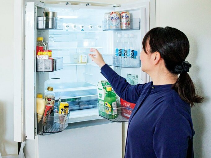 冷蔵庫の前に立つ女性