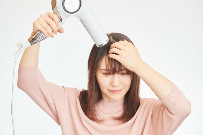 前髪を乾かす女性