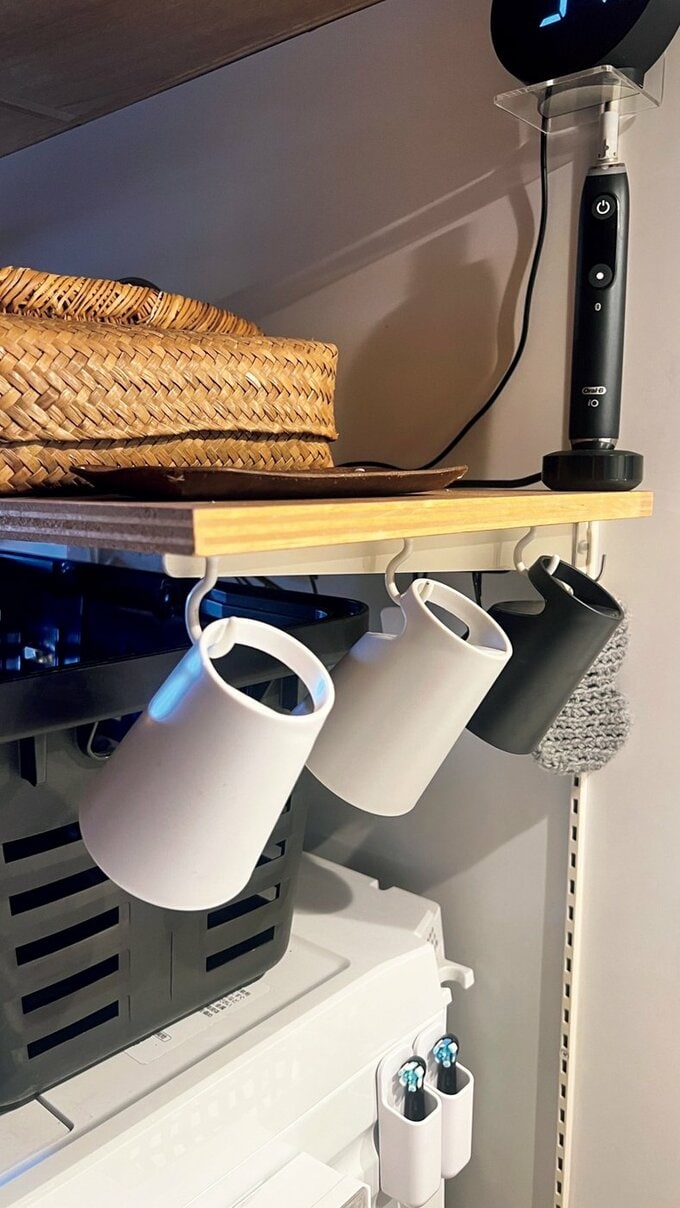 フックで棚にかけられたコップ