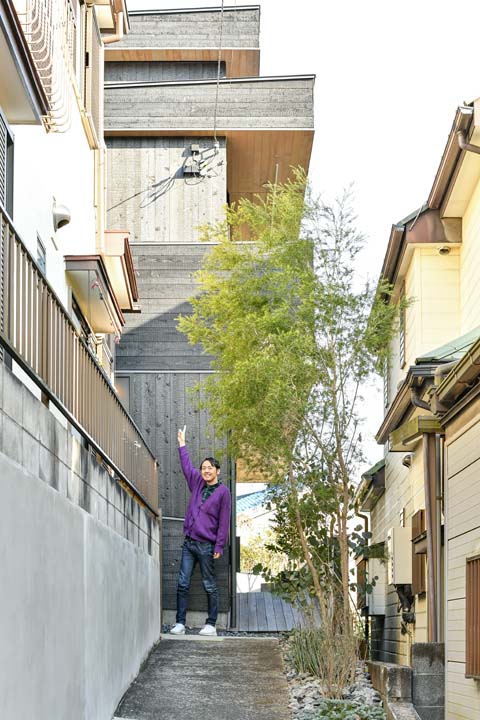 建物の前に立つ田中さん