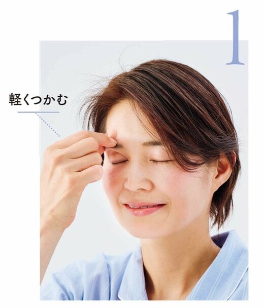 まゆ毛を軽くつかむ女性