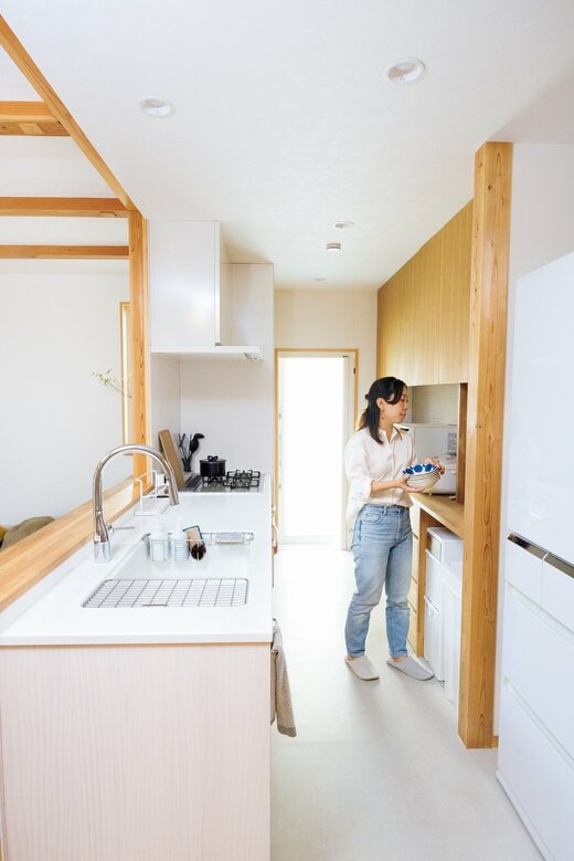 整理整頓されたキッチンで過ごす女性