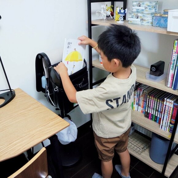 ランドセルに教科書を入れる子ども