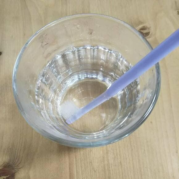 耐熱のコップに熱湯を注ぎ歯ブラシを入れる