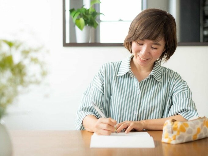 ノートにメモをする女性