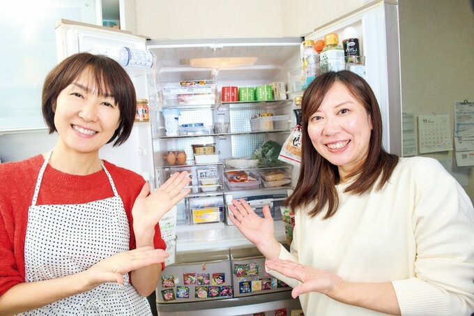 冷蔵庫の中身を笑顔で紹介する2人の女性