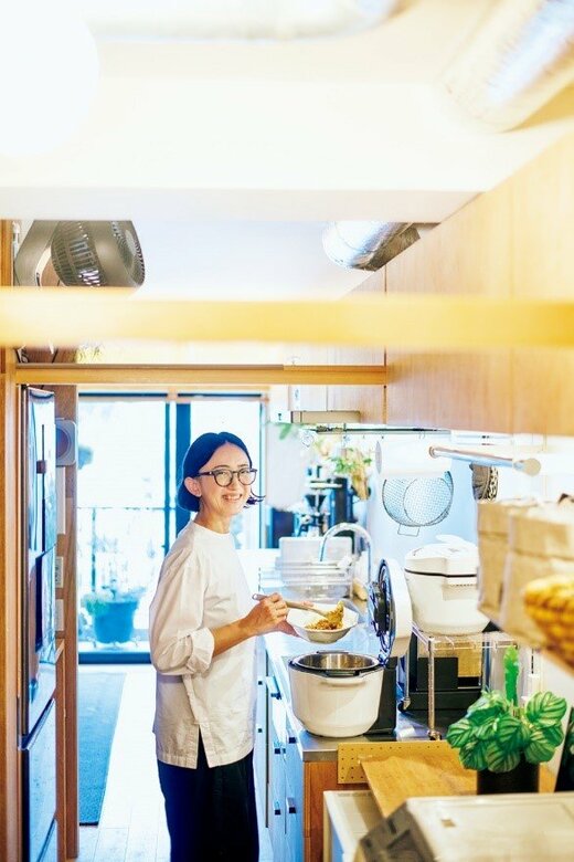 キッチンで料理をつぎ分ける女性