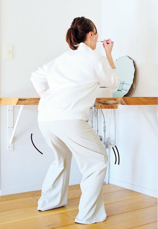 歯みがきをしながらストレッチをする女性