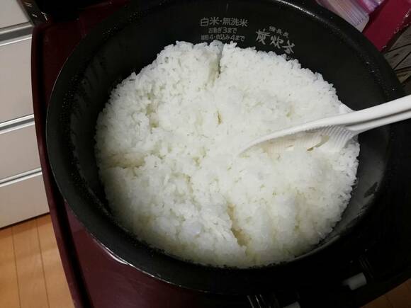 炊き上がった米をしゃもじで十字に切る様子