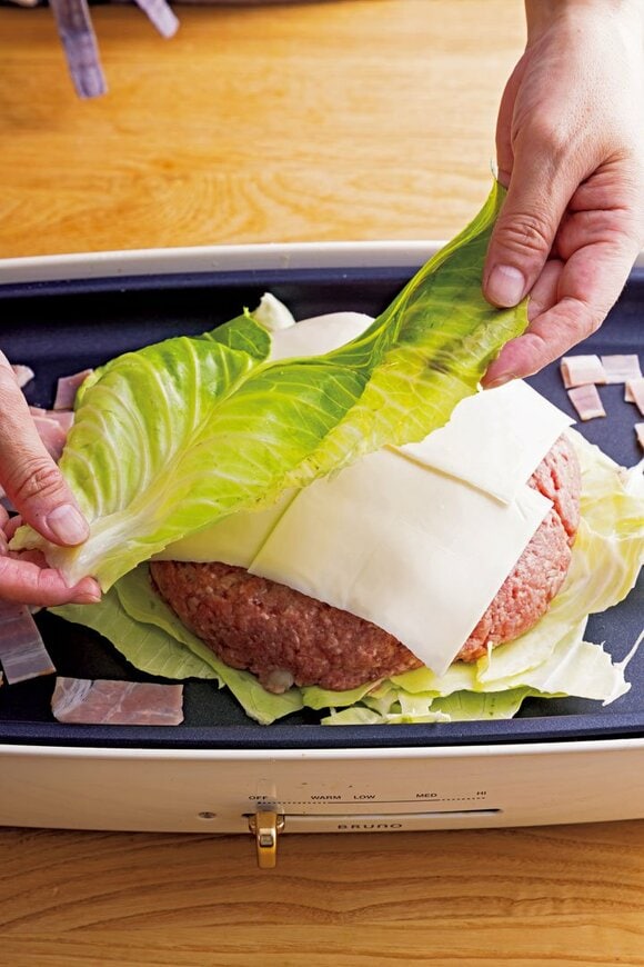 チーズの上にキャベツをのせる様子