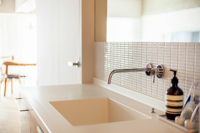 白のモザイクタイルでスッキリと清潔感のある印象に仕上げた洗面カウンター